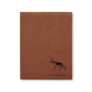 May include: Brown leather journal with a black silhouette of a German Shepherd dog and the text "Your Name Here" engraved on the front.