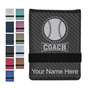May include: A black carbon fiber textured wallet with a black elastic strap. The front features a white baseball graphic surrounded by stars, the word COACH in a rectangular frame, and the text Your Name Here at the bottom. Twelve color variations are shown to the left.