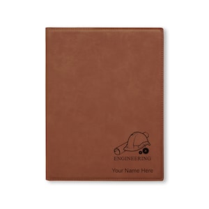 May include: Brown leather journal with an engraved design of a hard hat, blueprint, and gears. The text "ENGINEERING" and "Your Name Here" is engraved below the design.