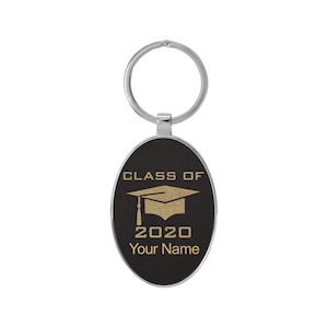 May include: Black oval keychain with a silver key ring. The keychain has gold text that reads "Class of 2020" and "Your Name" with a graduation cap graphic.