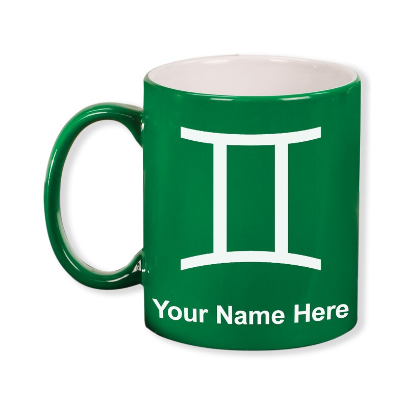 May include: A green ceramic mug with a white interior and handle. The mug features a white Gemini symbol and the text "Your Name Here" in white. The mug is designed for personalization.