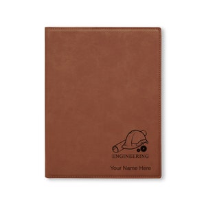 May include: Brown leather journal with an engraved design of a hard hat, blueprint, and gears. The text "ENGINEERING" and "Your Name Here" is engraved below the design.