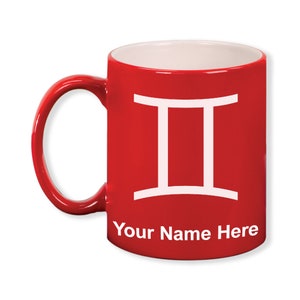 May include: A red ceramic mug with a white interior and handle. The mug features a white Gemini zodiac symbol and the text "Your Name Here" in white. The mug is designed for personalization.