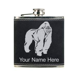 May include: A black leather-wrapped stainless steel flask with a silver gorilla graphic and the text "Your Name Here".