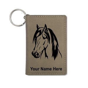 Puede incluir: Un llavero de cuero marrón con una silueta de cabeza de caballo negra y el texto "Your Name Here".