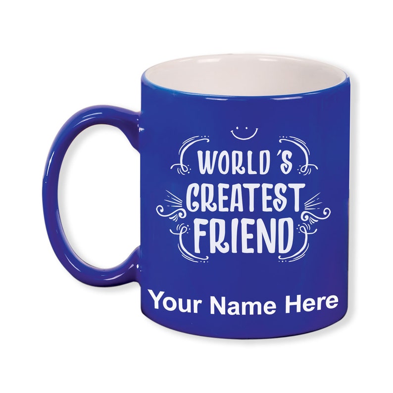 K&ouml;nnte beinhalten: Eine kobaltblaue Keramiktasse mit wei&szlig;em Innenraum und Henkel. Die Tasse tr&auml;gt den wei&szlig;en Schriftzug "WORLD'S GREATEST FRIEND", darunter Platz f&uuml;r eine Personalisierung. Ein kleines Smiley befindet sich &uuml;ber dem Text.