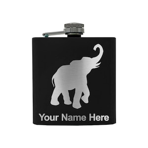 May include: Black flask with a silver elephant silhouette and a hinged cap. The text "Your Name Here" is printed in silver at the bottom. The flask has a silver cap and a small hinged spout.