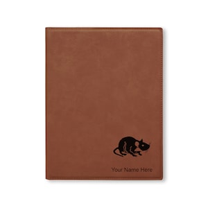 May include: Brown leather journal with a black silhouette of a rat and the text "Your Name Here" engraved on the front.