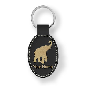 May include: Black leather oval keychain with a gold elephant silhouette and the text "Your Name".