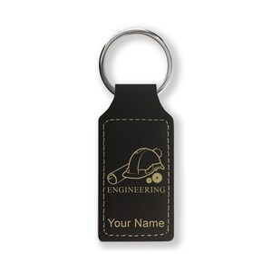 May include: Black leather keychain with a silver key ring. The keychain features a gold-colored engineering design with a hard hat, blueprint, and gears. The word "ENGINEERING" and "Your Name" are also displayed.