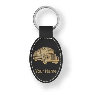 May include: Black leather oval keychain with a gold school bus silhouette and the text "Your Name".