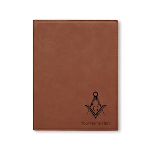 May include: Brown leatherette journal with a black engraved Masonic symbol and the text "Your Name Here".