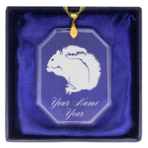 May include: A glass ornament with a white squirrel etched into it. The ornament is in a blue velvet box with a gold chain. The ornament also has the text "Your Name Year" engraved on it.
