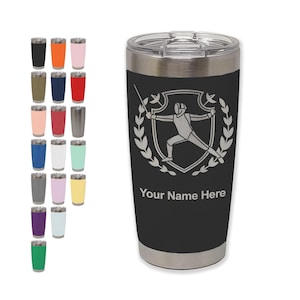May include: Black and silver insulated tumbler with a fencing design. The tumbler features a shield with a fencer, laurel wreath, and the text "Your Name Here". A variety of colored tumblers are displayed in the background.