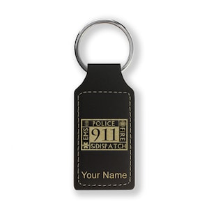 May include: Black leather keychain with a gold 911 dispatch emblem and the text "Police, Fire, EMS" around the number. The keychain also has the text "Your Name" at the bottom.