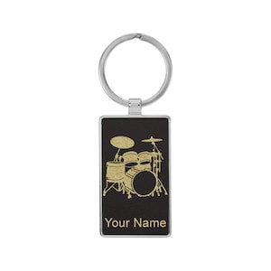 May include: A black leather keychain with a gold drum set design and the text "Your Name".