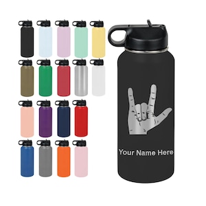 May include: A black insulated water bottle with a black lid and handle. The bottle features a silver hand gesture design and the text "Your Name Here". Assorted colored water bottles are displayed in the background.