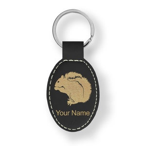 May include: Black leather oval keychain with a gold silhouette of a squirrel and the text "Your Name".