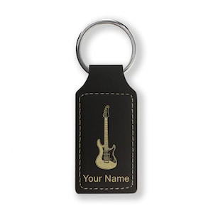 May include: Black leather keychain with a gold-colored electric guitar design and the text "Your Name".