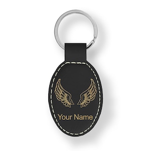 May include: Black leather oval keychain with a gold angel wing design and the text "Your Name".