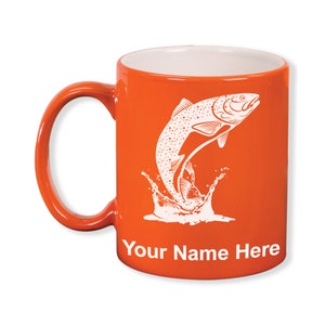 May include: Orange ceramic mug with a white interior and handle. The mug features a white graphic of a leaping fish with water splashes, and the text "Your Name Here" in white.