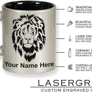 May include: Silver ceramic mug with a black interior, featuring a detailed black lion's head design. The mug includes the text "Your Name Here" and is from Lasergram, a custom engraved gifts company.
