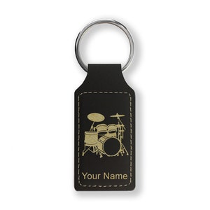 May include: Black leather keychain with a gold drum set graphic and the text "Your Name".