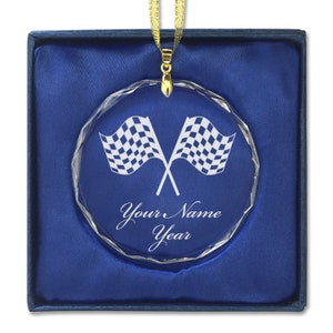 May include: A clear crystal ornament with a checkered flag design and the text "Your Name Year" engraved on it. The ornament is in a blue velvet box.