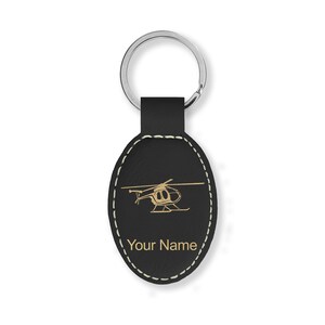 May include: Black leather oval keychain with a gold helicopter silhouette and the text "Your Name".