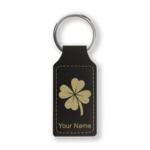 May include: Black leather keychain with a gold four-leaf clover design and the text "Your Name".