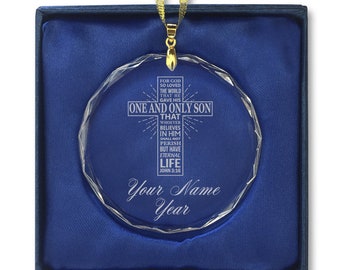 May include: A clear crystal ornament with a cross and the text "For God so loved the world that he gave his one and only son that whoever believes in him shall not perish but have eternal life John 3:16". The ornament is in a blue box with a gold ribbon.