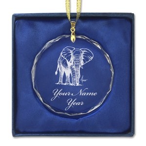 May include: A clear crystal ornament with a detailed etching of an elephant. The ornament is in a blue velvet box and has a gold ribbon attached. The ornament is personalized with the text "Your Name Year".