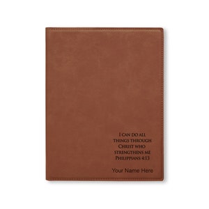 May include: A brown leather journal with the quote "I can do all things through Christ who strengthens me Philippians 4:13" and the text "Your Name Here" engraved on the front.