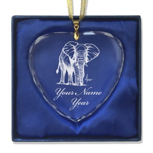 May include: A heart-shaped crystal ornament with an etched image of an elephant. The ornament is in a blue velvet box and has a gold ribbon attached. The ornament is personalized with the text "Your Name Year".