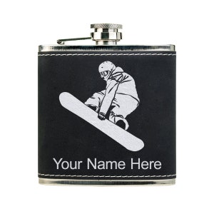 May include: A black leather-wrapped stainless steel flask with a silver cap. The flask features a white silhouette of a snowboarder and the text "Your Name Here".