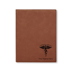 May include: A brown leatherette portfolio with the word "Veterinarian" and a caduceus symbol. The text "Your Name Here" is below the symbol. The portfolio is rectangular and has a smooth texture.