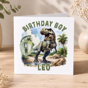 A birthday card featuring a dinosaur, specifically a T-Rex, with the text "BIRTHDAY BOY" and "LEO" printed on it.