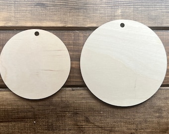May include: Two unfinished wooden circles with holes in the top, perfect for crafting projects. The circles are different sizes, with the larger circle being about 6 inches in diameter and the smaller circle being about 4 inches in diameter.