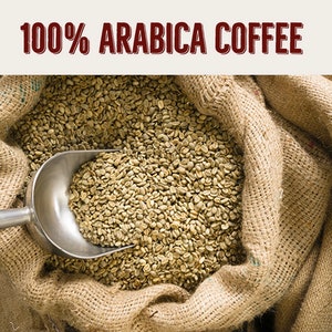 Puede incluir: Un saco de arpillera lleno de granos de caf&eacute; verde. Una pala de metal est&aacute; parcialmente llena de granos y descansa sobre el saco. El texto "100% ARABICA COFFEE" se muestra sobre el saco.