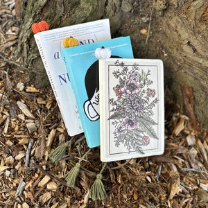 May include: Three books with crocheted bookmarks. The top book is titled "A Mind for Numbers". The middle book is titled "a beautiful, funny and sometimes quite transformative..." The bottom book has a floral design on the cover.