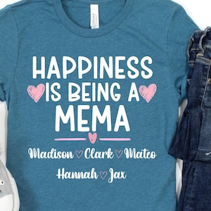 Könnte beinhalten: Ein blaugrünes Kurzarm-T-Shirt mit weißem Text "HAPPINESS IS BEING A MEMA" und rosa Herzgrafiken, gefolgt von den Namen "Madison", "Clark", "Mateo", "Hannah" und "Jax", die durch kleine Herzen getrennt sind, kombiniert mit einer dunkelblauen Jeans.