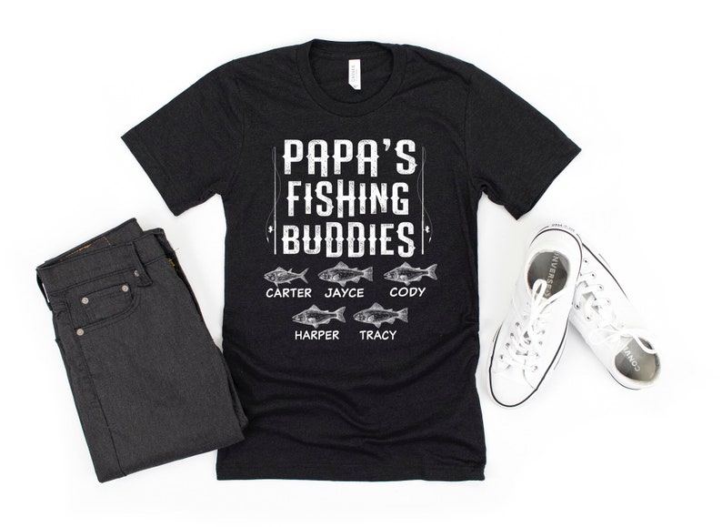 Puede incluir: Camiseta negra con texto blanco que dice "Papa's Fishing Buddies" y enumera los nombres "Carter, Jayce, Cody, Harper, Tracy" con un gr&aacute;fico de pescado al lado de cada nombre.