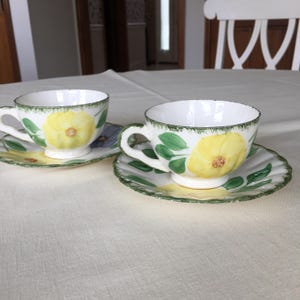 May include: A set of three ceramic mugs with a speckled, matte finish. The mugs are in shades of cream, light gray, and dark gray. Each mug has a simple, minimalist design and a rounded handle. The mugs are likely for coffee or tea.