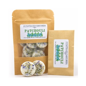 Puede incluir: Una bolsa de papel marrón etiquetada 12 PASTILLES PARFUMÉES PATCHOULI y un sobre de papel marrón más pequeño etiquetado 2 PASTILLES PARFUMÉES PATCHOULI, ambos con pastillas de cera blancas con flores azules y hierbas secas incrustadas.