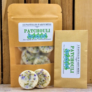 Peut inclure: Deux sachets en papier kraft avec des étiquettes indiquant "12 Pastilles Parfumées Patchouli" et "2 Pastilles Parfumées Patchouli". Les sachets contiennent de petites pastilles de cire rondes avec un motif floral. Les pastilles de cire sont faites avec de l'huile végétale de colza.