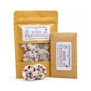 Pode incluir: Uma bolsa de papel castanho contendo 12 pastilhas de cera brancas com pétalas de flores secas e um rótulo com a inscrição 12 PASTILLES PARFUMÉES ROSE PATCHOULI, ao lado de um envelope de papel castanho menor com o rótulo 2 PASTILLES PARFUMÉES ROSE PATCHOULI.