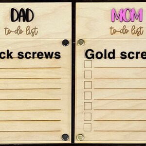 Pode incluir: Dois quadros de madeira para listas de tarefas com parafusos pretos e dourados. O quadro da esquerda tem a palavra "DAD" e "to-do list" escrita nele. O quadro da direita tem a palavra "MOM" e "to-do list" escrita nele.