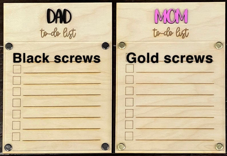 Pode incluir: Dois quadros de madeira para listas de tarefas com parafusos pretos e dourados. O quadro da esquerda tem a palavra "DAD" e "to-do list" escrita nele. O quadro da direita tem a palavra "MOM" e "to-do list" escrita nele.