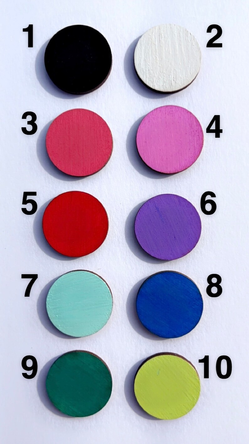 Pode incluir: Dez discos redondos de madeira pintados em diferentes cores, numerados de 1 a 10. As cores s&atilde;o preto, branco, rosa, vermelho, roxo, azul claro, azul escuro, verde e amarelo.