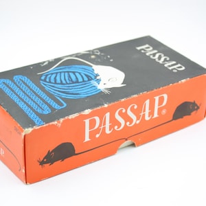 May include: A vintage orange and black box with the word "PASSAP" in white. The box features illustrations of a white mouse, blue yarn, and black mice. The box is likely for a knitting or craft product.
